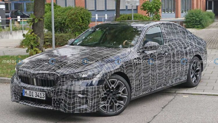 BMW M5 spotted with production headlights & thinner camouflage